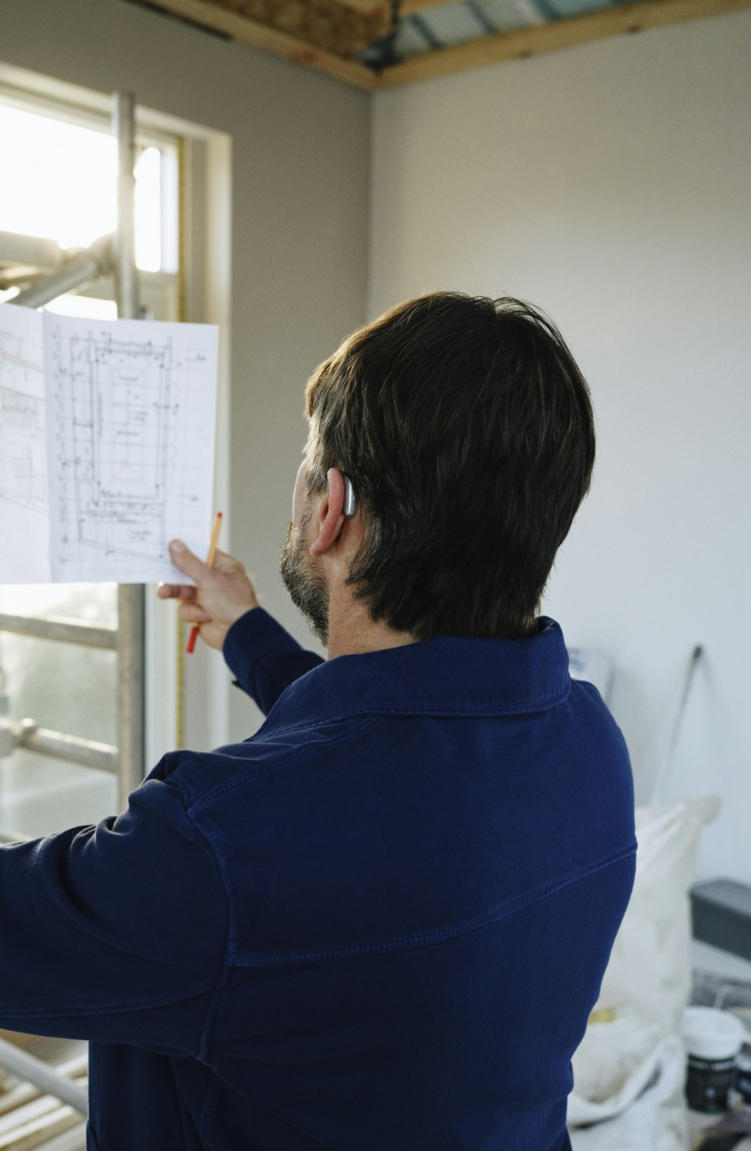 Engineer checking a technical drawing against the light.